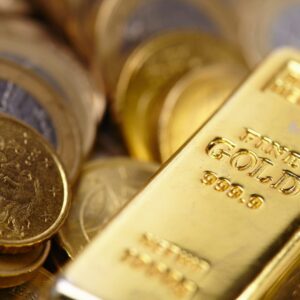 A gold bar sitting on top of some coins.