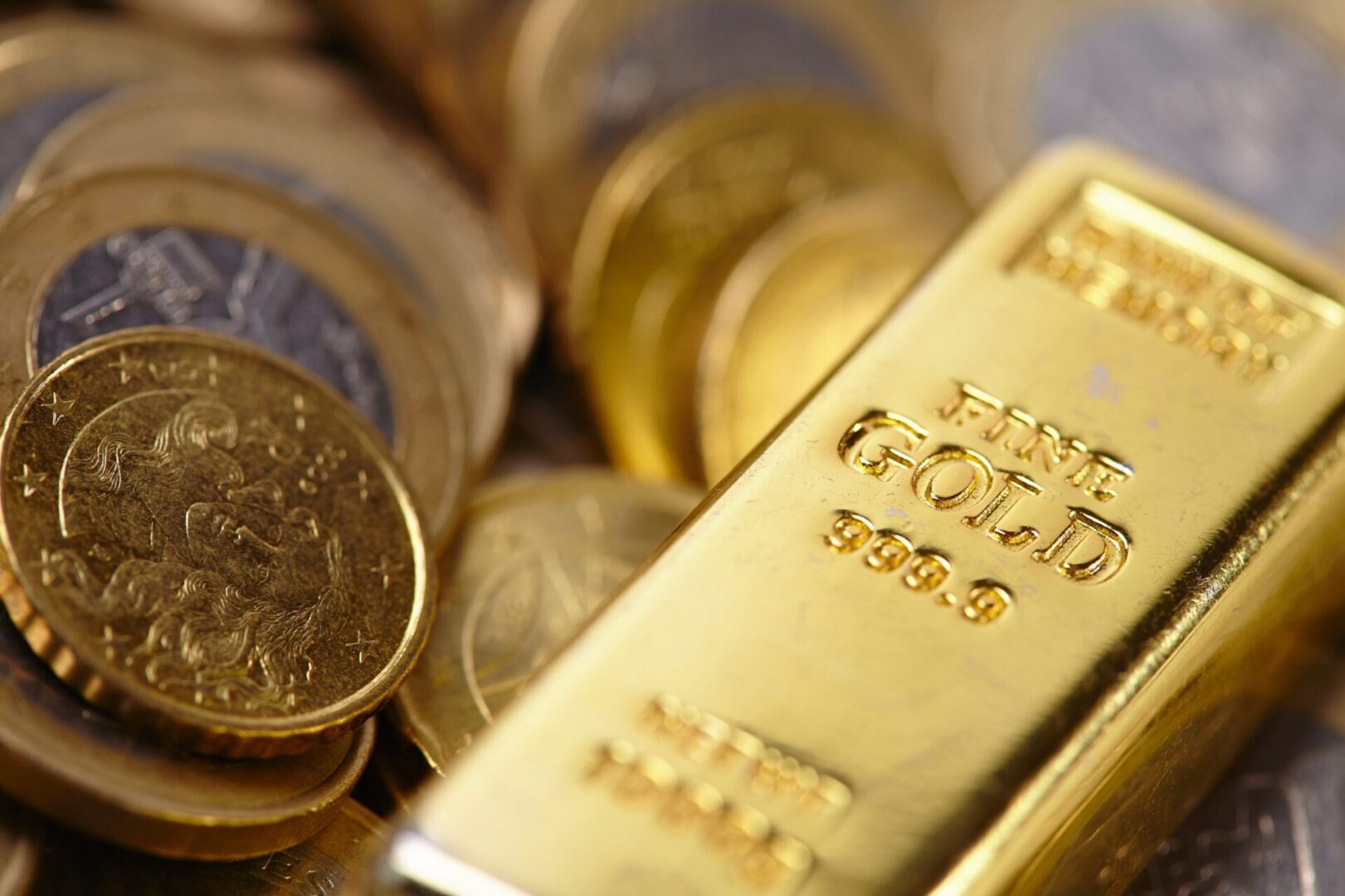 A gold bar sitting on top of some coins.